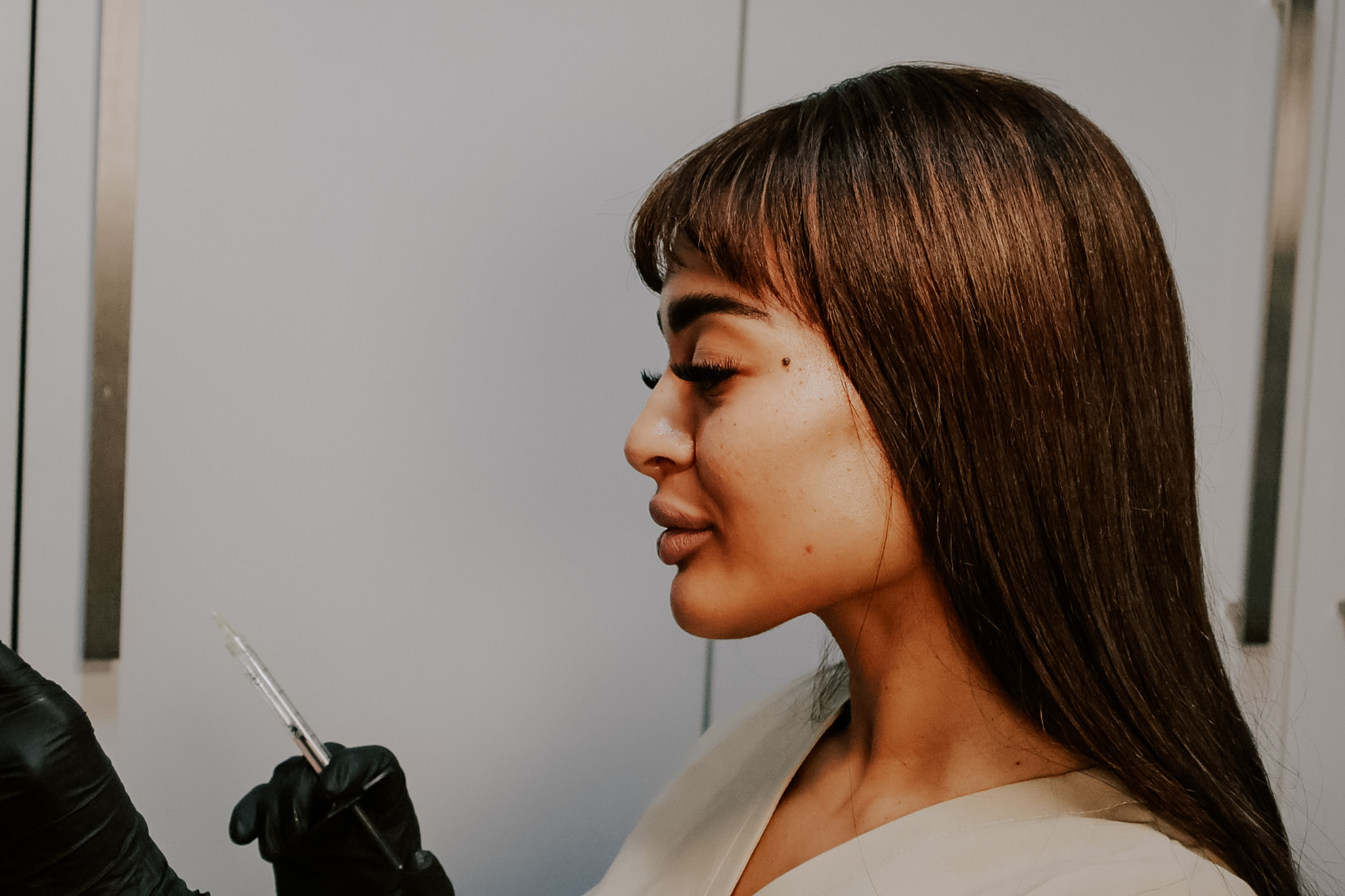 Dr Fawzia holding dermal filler syringe